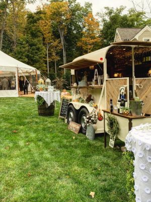 The Thirsty Filly's mobile bar set up on a lawn beside a reception tent with cocktail tables and a drink station
